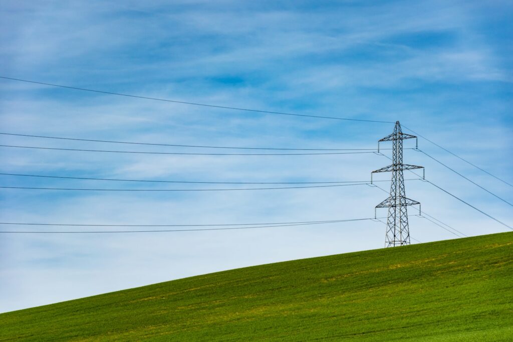 Electrical tower on a grass field, representative image
