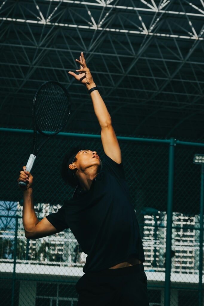 Man holding a tennis racquet on court, representative image