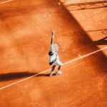 Man playing tennis on a court, representative image