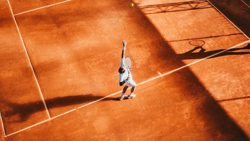 Man playing tennis on a court, representative image