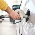 Man refuelling a car at a petrol pump, representative image