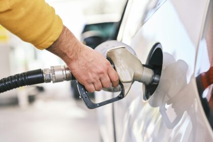 Man refuelling a car at a petrol pump, representative image