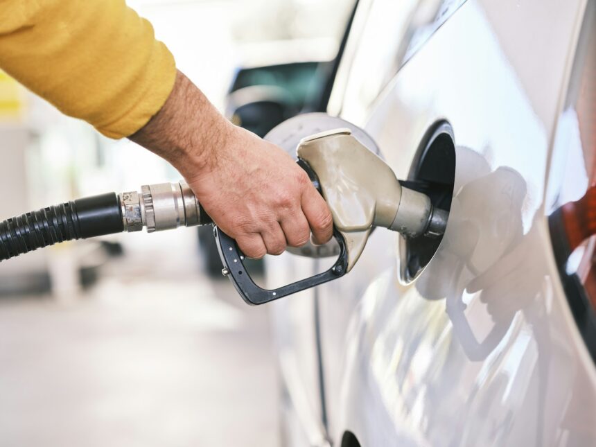 Man refuelling a car at a petrol pump, representative image