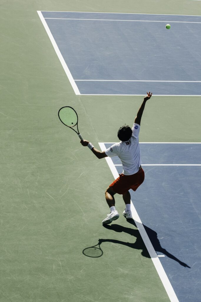 Man swinging a tennis racquet on court, representative image