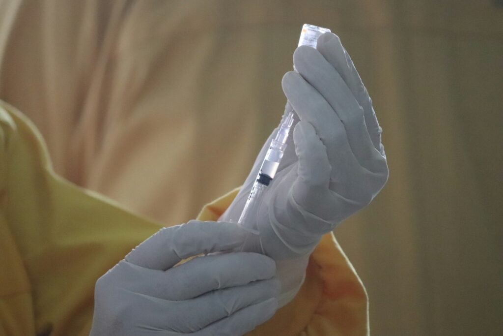 Person holding a white plastic tube, representative image