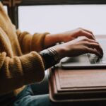 Person sitting in front of a laptop, representative image