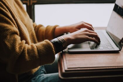 Person sitting in front of a laptop, representative image