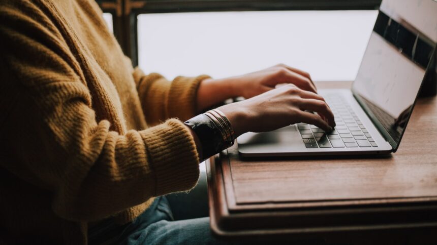 Person sitting in front of a laptop, representative image