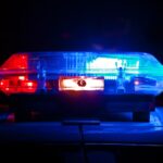 Police light bar flashing red and blue at night, representative image