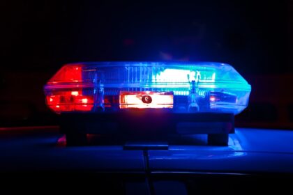 Police light bar flashing red and blue at night, representative image