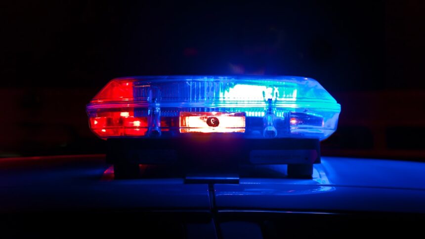 Police light bar flashing red and blue at night, representative image