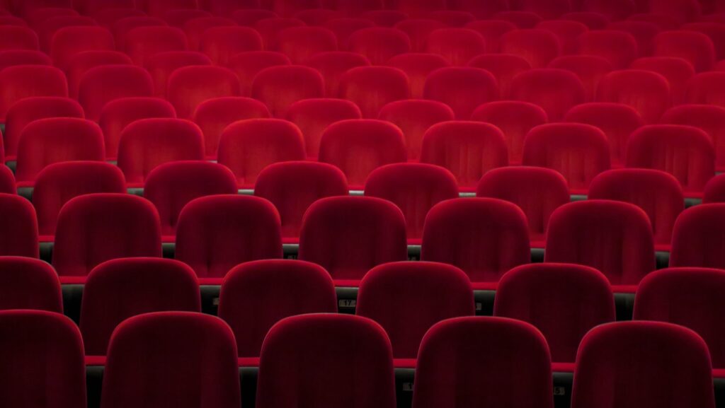 Red padded theater chairs, representative image