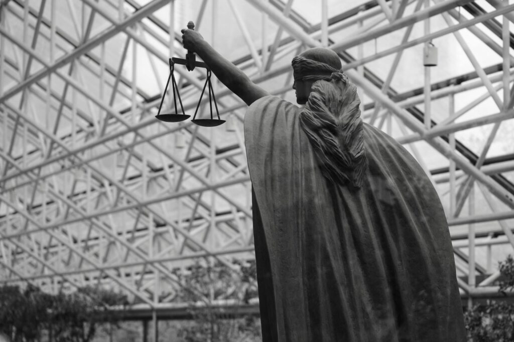 Statue of lady justice holding scales indoors, representative image
