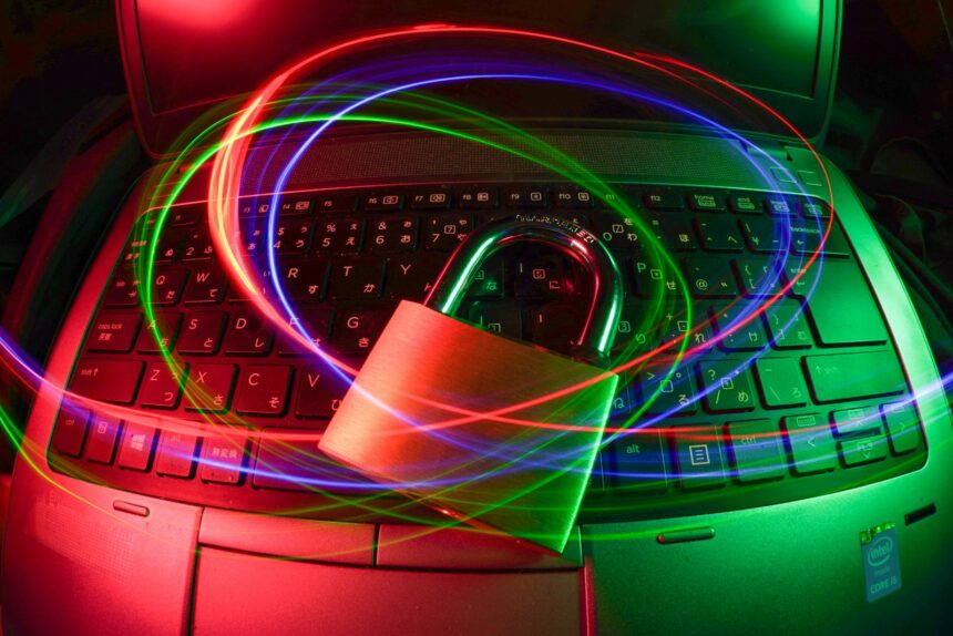 Cybersecurity concept image of a padlock on a laptop with light trails