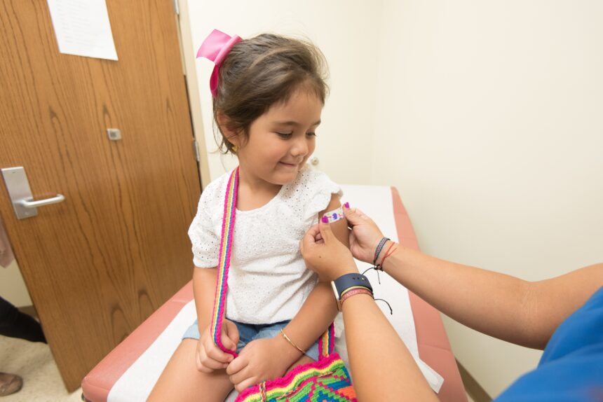 Health worker administers a vaccination to a young child