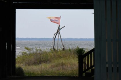 Flag flutters outside a home as Hurricane Isaias nears Dauphin Island, Alabama