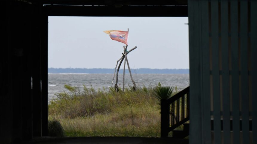 Flag flutters outside a home as Hurricane Isaias nears Dauphin Island, Alabama
